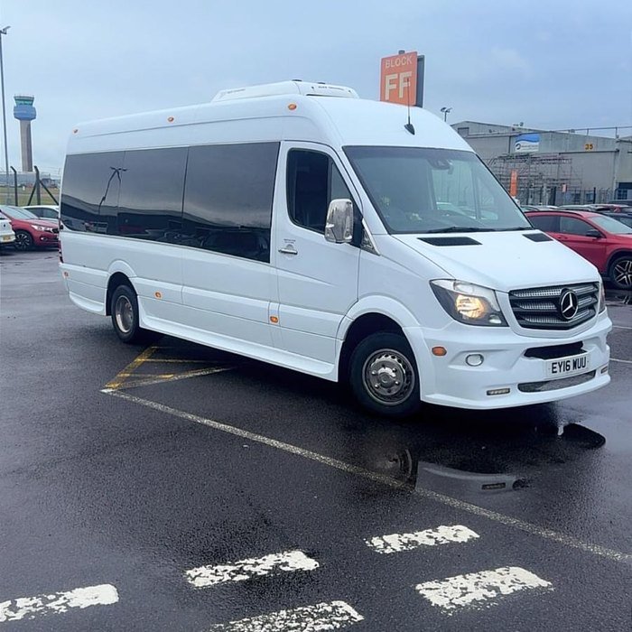 ATS Travel 16-seater minibus waiting at East Midlands Airport on a wet early morning