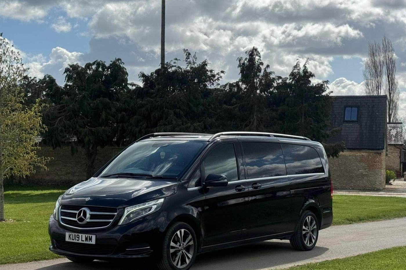 Black Mercedes-Benz V-Class executive people carrier operated by ATS Travel, parked on a country estate driveway near Derby
